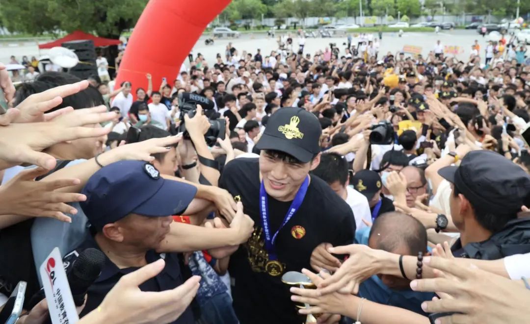 数千名师生在MK.COM大学城正门口迎接篮球队凯旋。